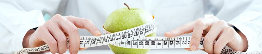 The girl measures an apple with a centimeter ribbon